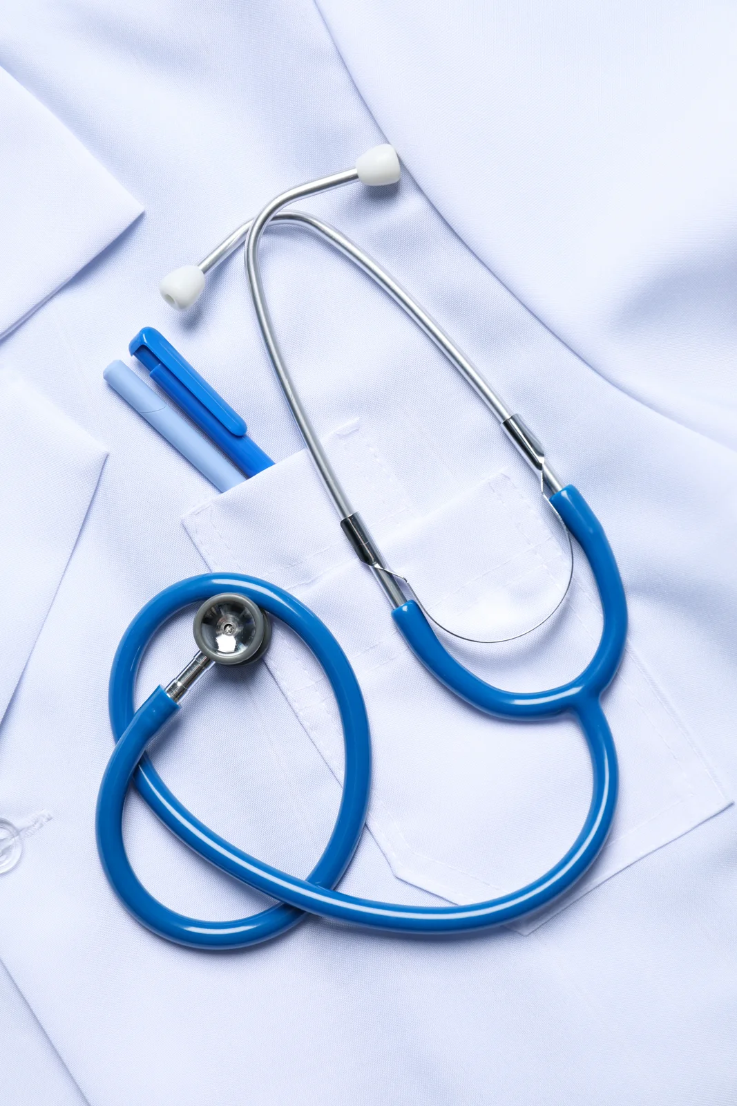 A stethoscope and medical coat on a light background
