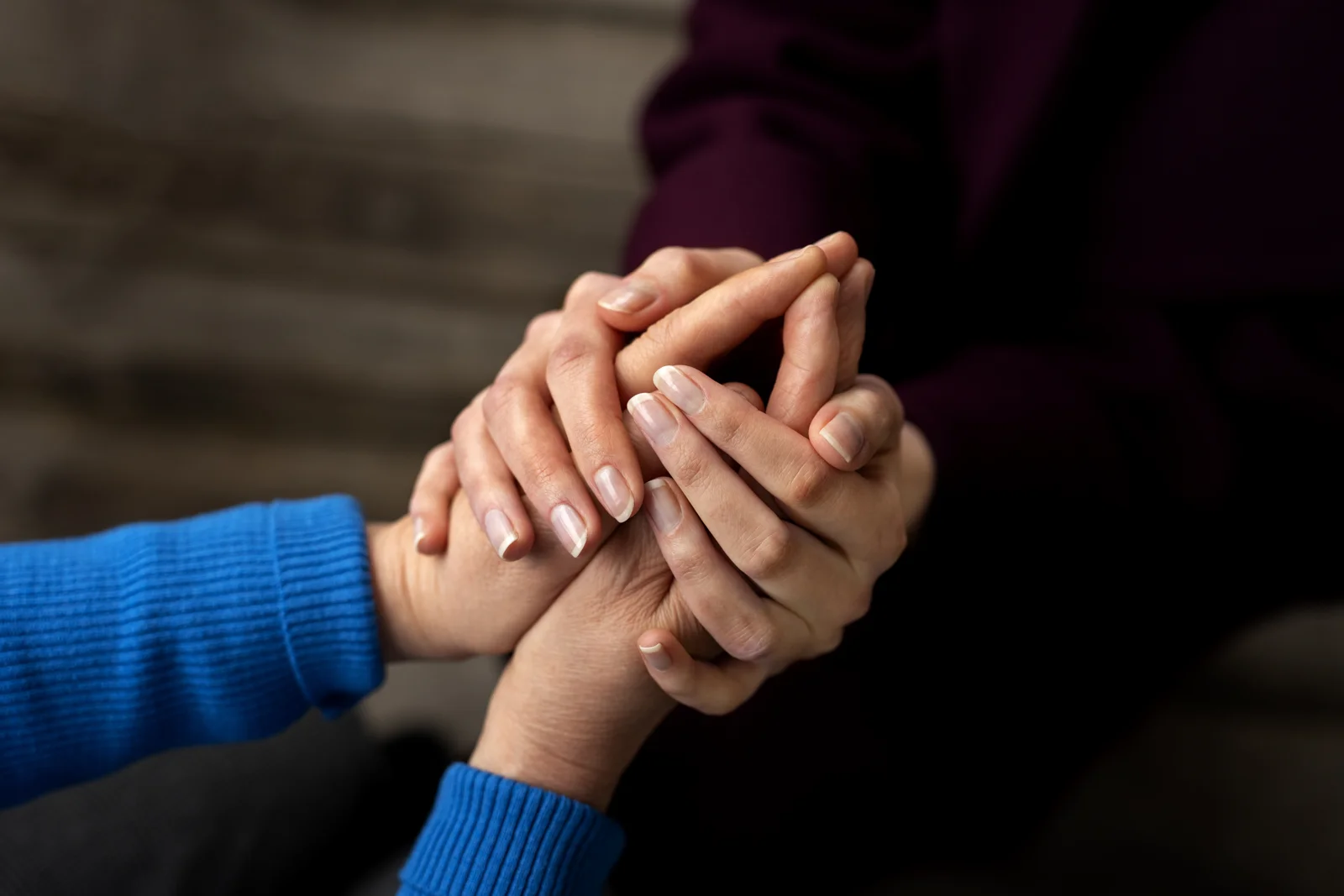 Two people holding hands in a gesture of support